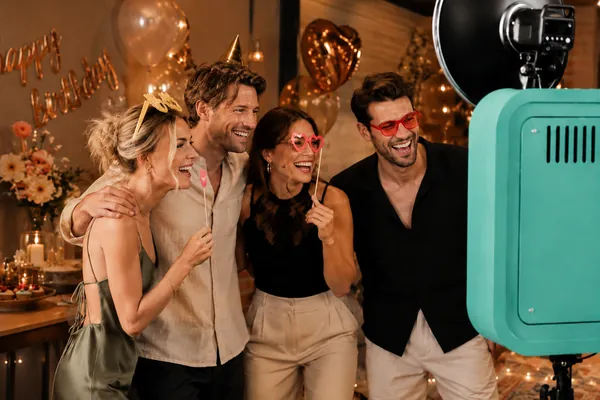 Freunde mit Requisiten an der Fotobox an einem Geburtstag